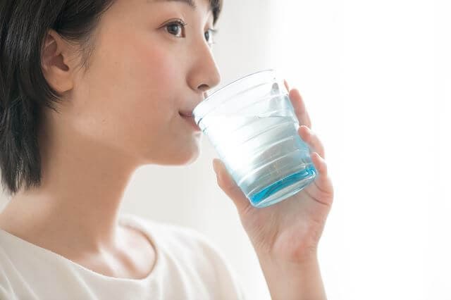 経口補水液を飲む女性